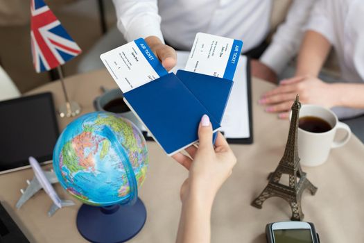 Close-up of passports and tickets in the hands of a travel agent in the office.