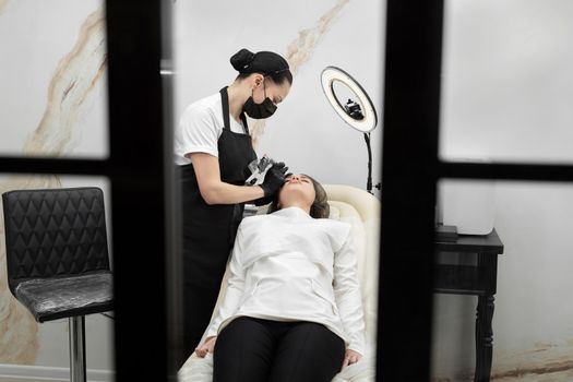 Permanent eyebrow makeup procedure. Eyebrow tattooing, the process in the salon.