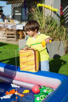 Fishing in the children's pool. Little boy's games.