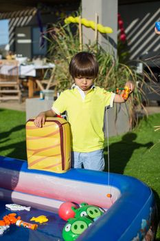 Fishing in the children's pool. Little boy's games.