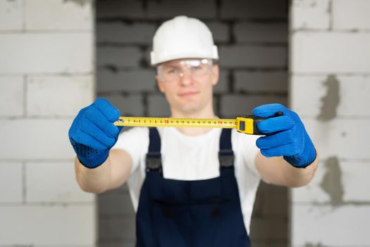 Portrait of a male construction worker in a helmet holding a roulette wheel.