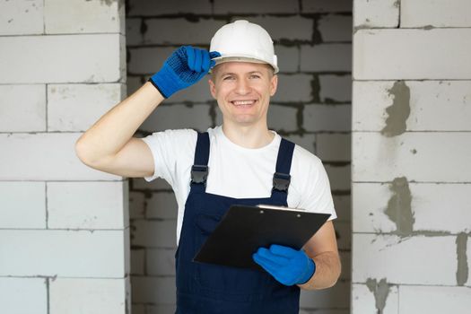 Construction engineer in a white helmet and a tablet on a construction site.