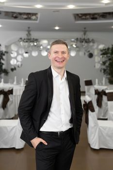 Young cheerful man in a suit in a restaurant.