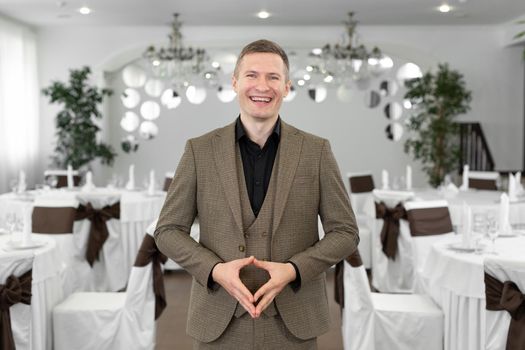 Young cheerful man in a suit in a restaurant.