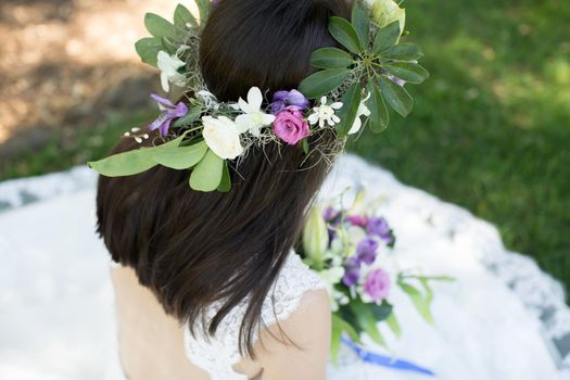 Beautiful young bride in a wreath with a bouquet in hand