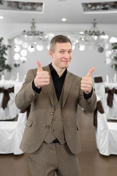 Young cheerful man in a suit in a restaurant.