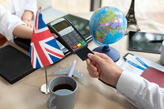 Close-up payment of tickets at a travel agency through a bank terminal.