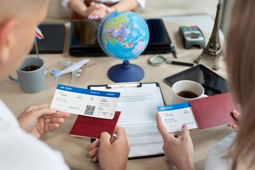 Close-up of passports and tickets in the hands of travelers at a travel agency.