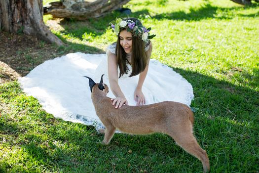 A bride in a white dress with a live trot on a green lawn.