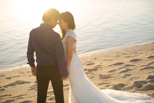 bride and groom meet the sunset on the beach