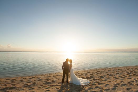 bride and groom meet the sunset on the beach