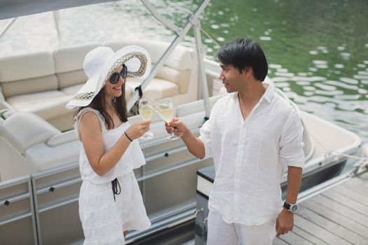 Smiling young couple holding glasses with champagne and looking at each other