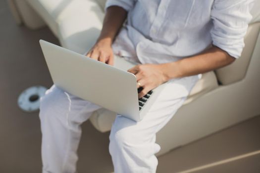 Businessman working with computer on a boat, nice outdoor office