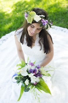 Beautiful young bride in a wreath with a bouquet in hand