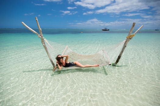 Woman in hammock on tropical beach at island
