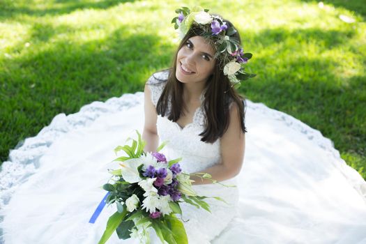 Beautiful young bride in a wreath with a bouquet in hand