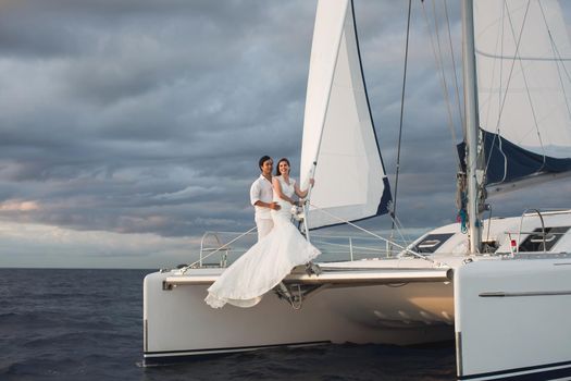 Wedding couple is hugging on a yacht. Beauty bride with groom.