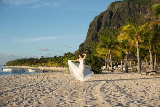 Beautiful bride in white dress on the beach