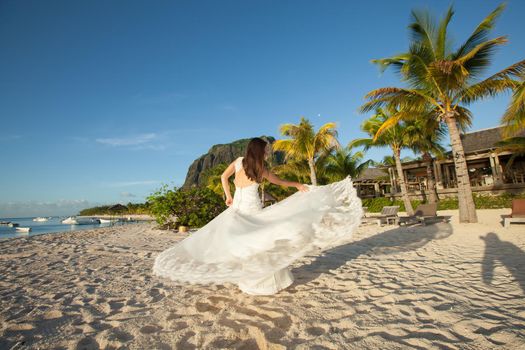 Beautiful bride in white dress on the beach