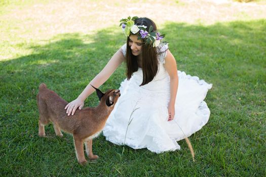 A bride in a white dress with a live trot on a green lawn.