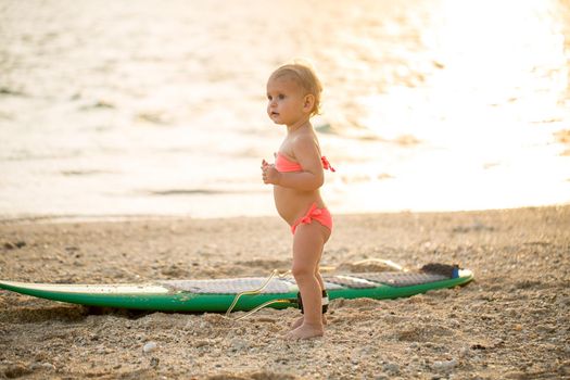 A little girl learns to surf on the ocean