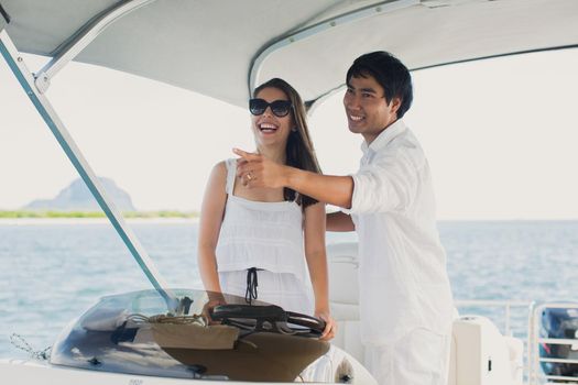 Young couple navigating on a yacht in Indian ocean