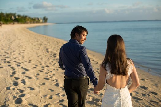 bride and groom walking on the beach of Mauritius