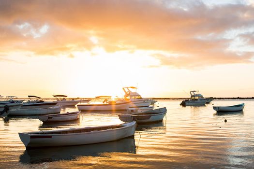 Small boats in the ocean at sunset