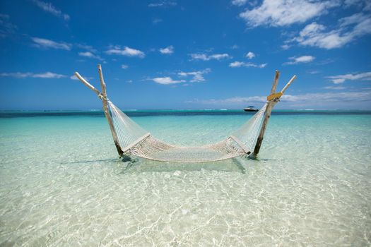 Empty over-water hammock in the middle of tropical lagoon