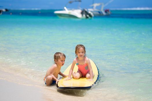 Twins brother and sister to have fun with surfing in the ocean