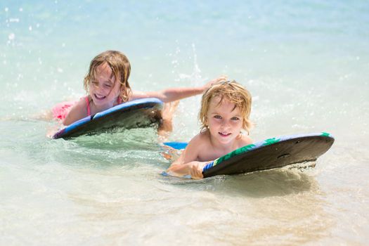 Twins brother and sister to have fun with surfing in the ocean