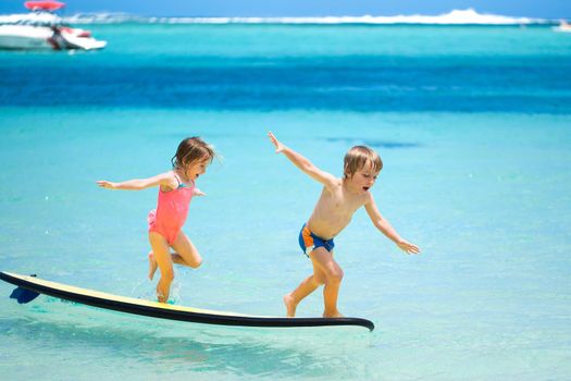 Twins brother and sister to have fun with surfing in the ocean