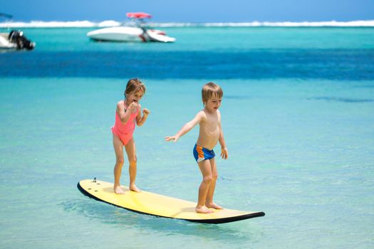 Twins brother and sister to have fun with surfing in the ocean