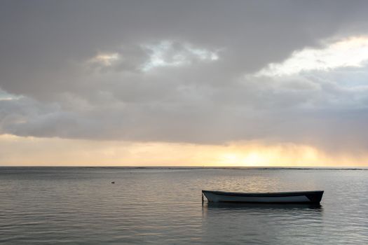 Beautiful sunset in the ocean with a fishing boat.