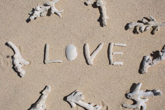 word Love from corals on sand of tropical beach