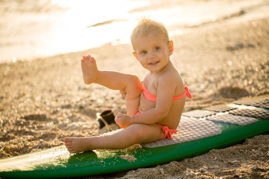 A little girl learns to surf on the ocean