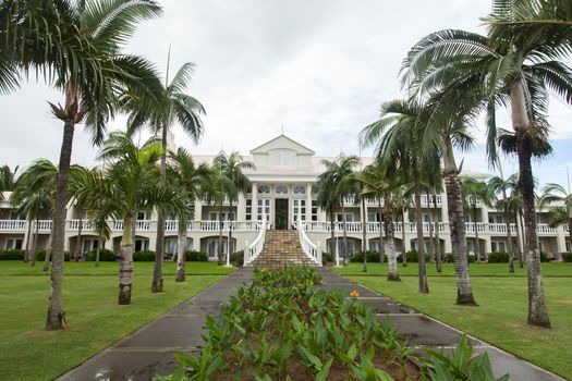 Luxury house in Mauritius, with a green lawn and palm trees.