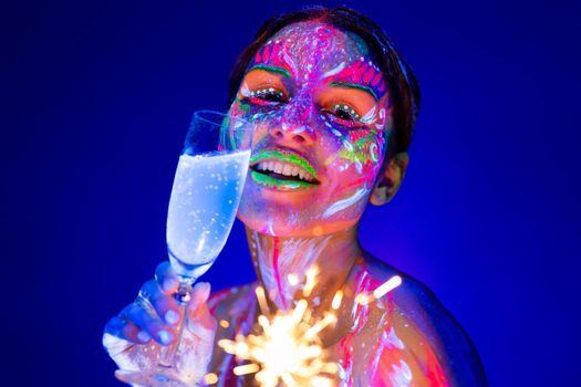 Woman with sparkler and glass of champagne in neon light. Holiday and new year concept