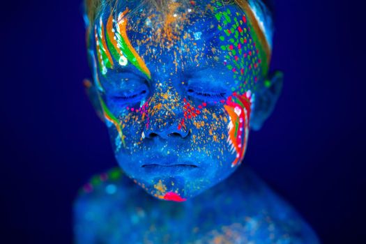 Portrait of a neon child boy posing in UV