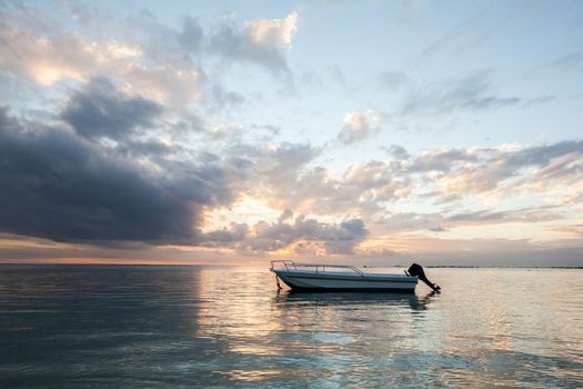 Beautiful sunset in the ocean with a fishing boat.