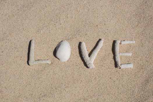 word Love from corals on sand of tropical beach