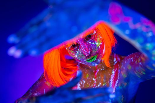 Neon Woman dancing. Fashion model woman in neon light, portrait of beautiful model with fluorescent make-up, Art design of female disco dancer posing in UV, colorful make up