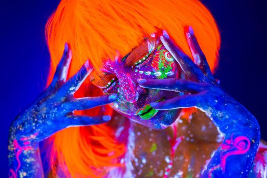 Neon Woman dancing. Fashion model woman in neon light, portrait of beautiful model with fluorescent make-up, Art design of female disco dancer posing in UV, colorful make up