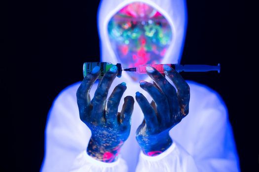 Doctor in ultraviolet neon light is holding COVID-19, oronavirus vaccine and syringe using for prevent infection. Medicine and Healthcare concept