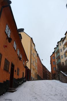 Street of colourful traditional Swedish houses in the winter snow in Sodermalm, south Stockholm, Sweden. High quality photo.