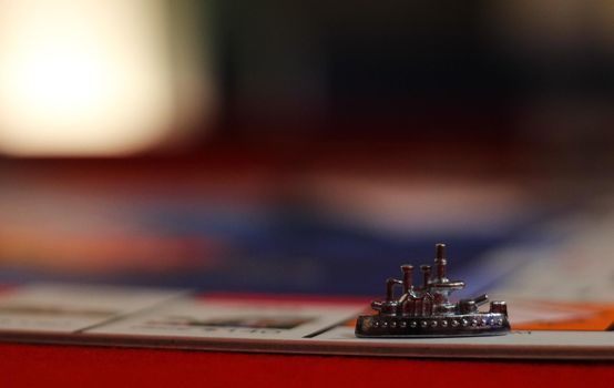 Metal ship game board piece preceding a blurred background, Hampshire, UK. High quality photo.