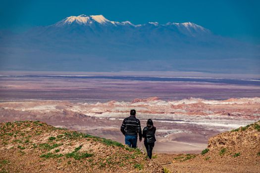 Rear view of couple looking to atacama desert salar with Pular volcano in the background