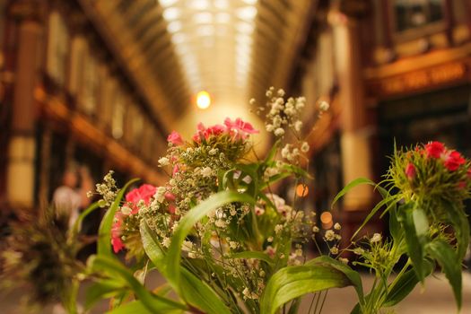 Close up of a bouquet of flowers with a blurred background, preceding the traditional 'Leadenhall market' in central London, UK. High quality photo.