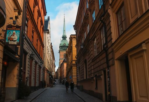 Dark traditional Swedish street, heading towards the cathedral in Gamla Stan, Stockholm, Sweden. High quality photo.