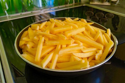 Yellow sliced potatoes in a frying pan